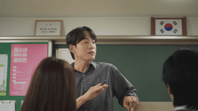 교탁 옆에 서서 학생들과 소통하는 선생님