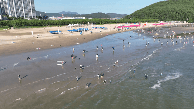 사람들이 햇볕을 즐기는 붐비는 모래 해변