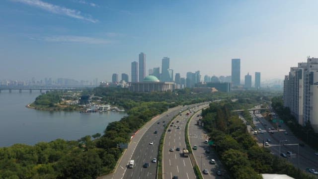 빌딩 스카이라인이 보이는 강변 도시의 분주한 도로