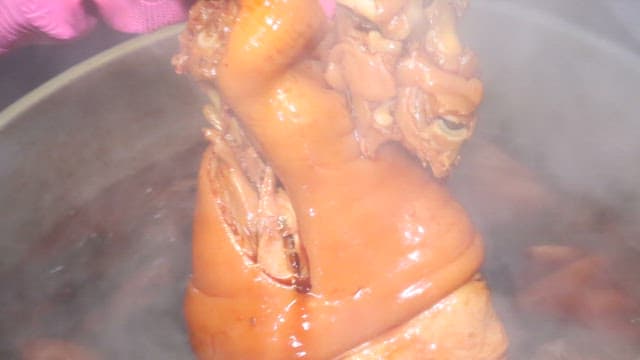 Pig's feet cooked in a large cauldron