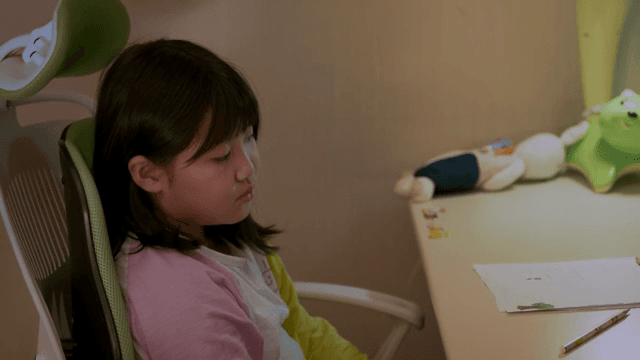 책상에 앉아 누군가와 대화하는 아이