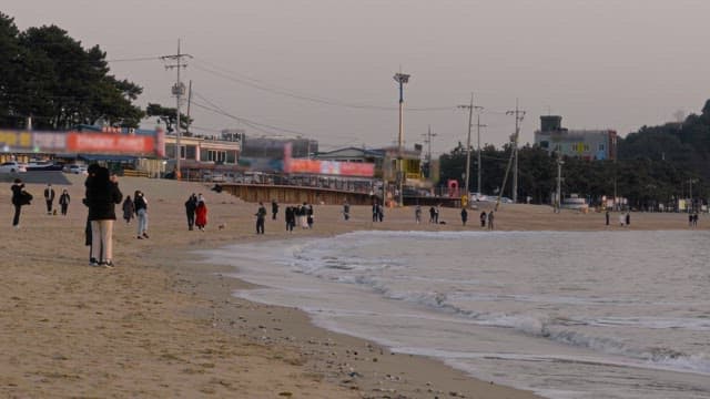 People enjoying an evening on the beach with waves crashing in