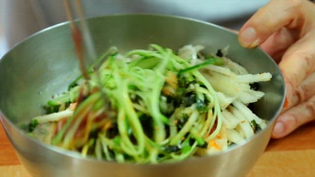 Stirring cold raw fish soup with chopsticks