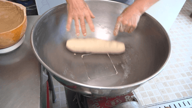 큰 그릇에서 반죽을 치대는 손