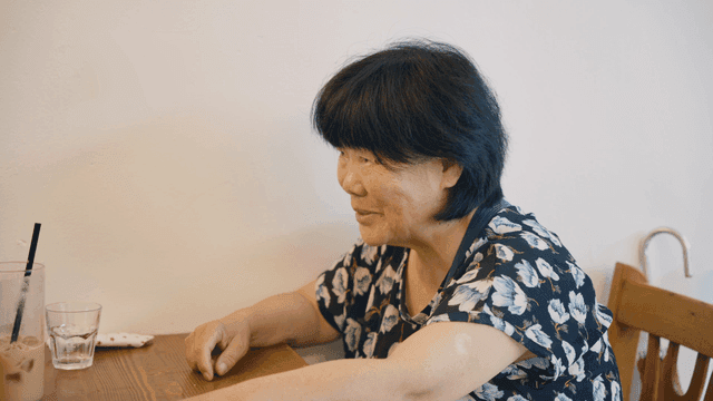 An elderly woman having a conversation at a cafe