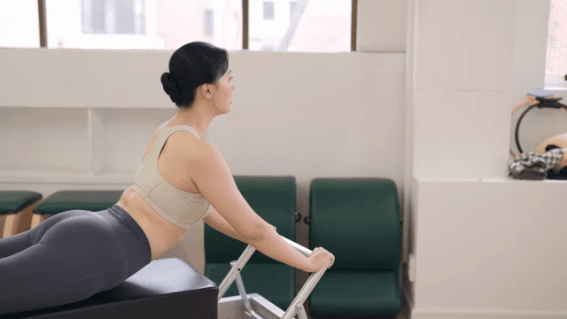 Woman practicing pilates on a reformer
