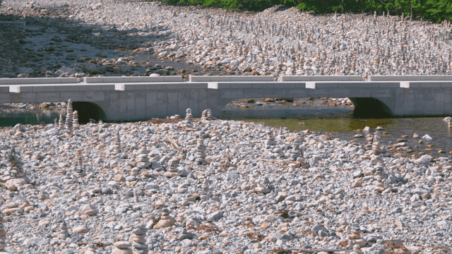 다양한 돌탑들과 깔끔한 다리가 있는 시냇물