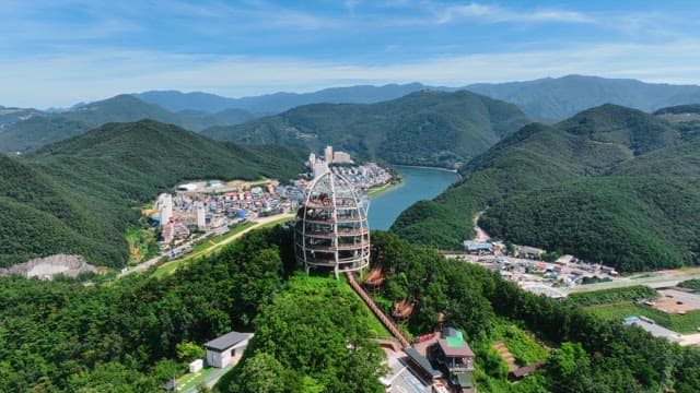 독특하게 생긴 전망대가 있는 푸른 산의 전경