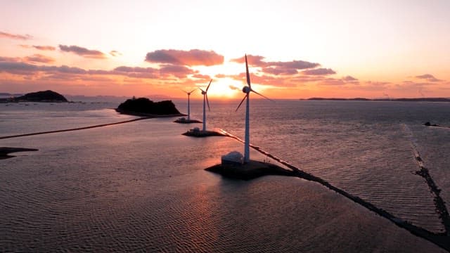 Wind turbines at sea during sunset