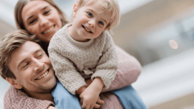 Happy Caucasian family carrying child