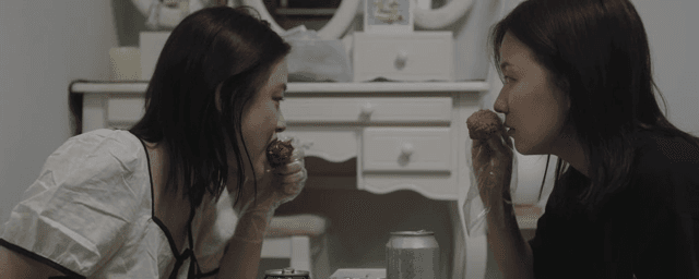 실내에서 치킨을 즐기는 두 여성