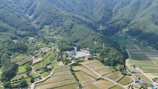논밭과 사찰 위로 펼쳐진 산자락 풍경