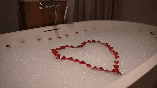 장미 꽃잎으로 하트 모양을 만든 욕조