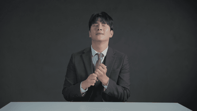 만족스러운 표정으로 책상에서 돈을 세는 정장 입은 남자