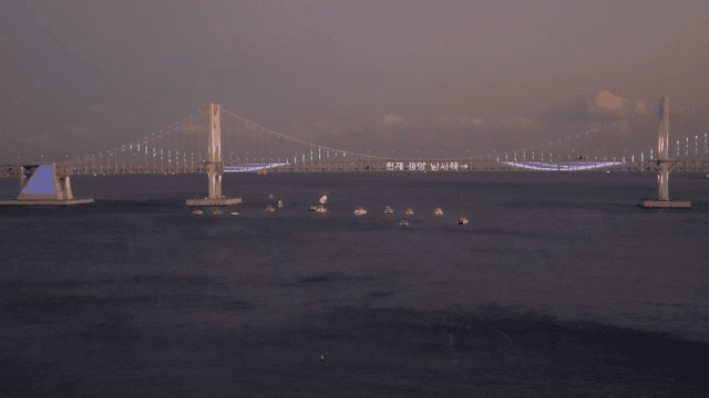 해질녘 조명이 켜진 다리와 보트