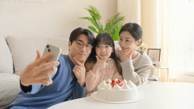Family taking a selfie with a cake