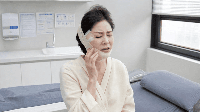 Female patient recovering from facial surgery at clinic