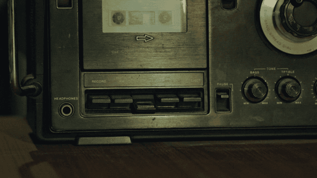 카세트 플레이어 버튼을 누르는 손