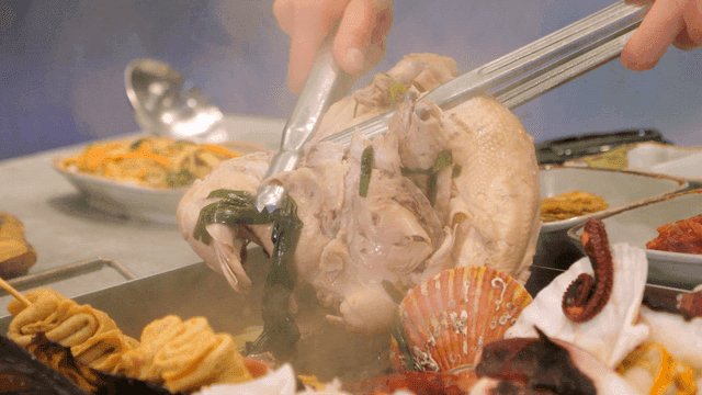 Boiled Haecheontang chicken lifted with tongs