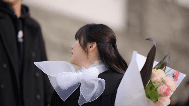 Graduates holding bouquets of flowers