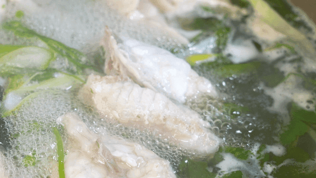 Clear pufferfish soup boiling in pot