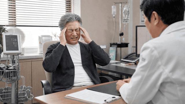 Elderly man suffering from headaches receiving medical treatment from doctor