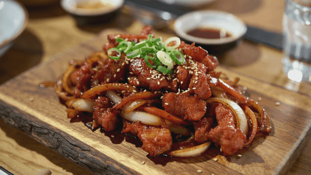 Spicy stir-fried pork on wooden cutting board