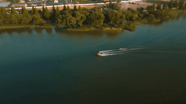 Boats crossing tranquil lake, water skiing