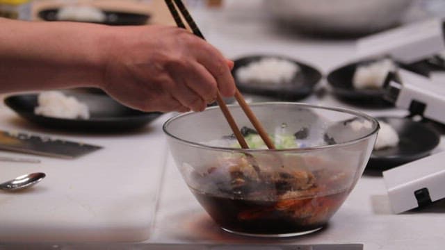 부엌에서 양념에 잘 절여진 조기를 프라이팬에 올리는 모습
