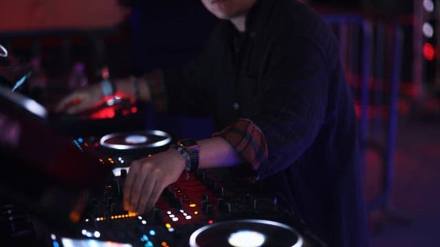 DJ Performing at a Club with Vibrant Lighting