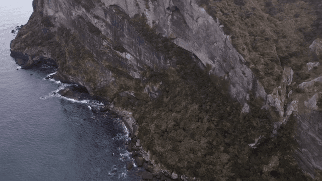 A rugged cliffside meeting the ocean waves