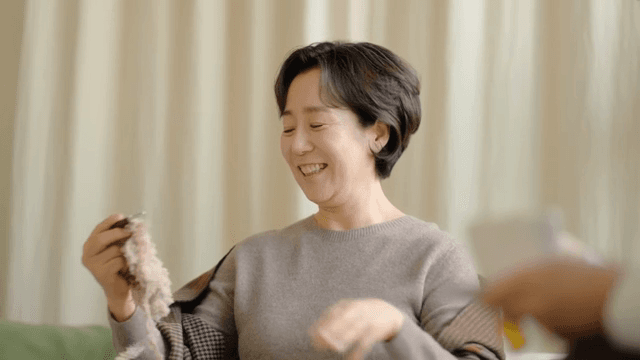 실내에서 행복하게 뜨개질하는 여성