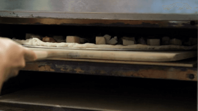 오븐에 피자를 넣는 장면