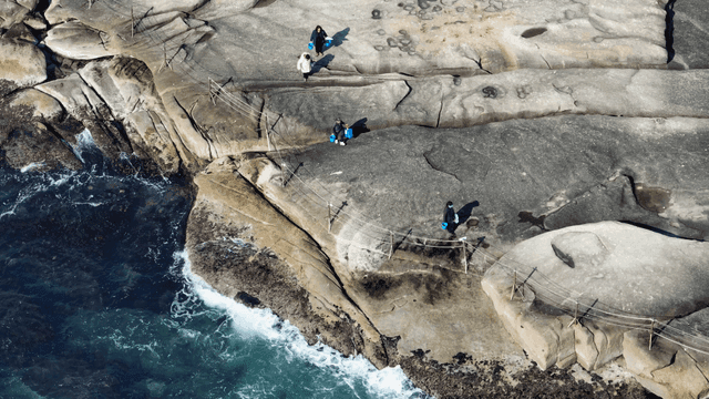 바닷가 바위 해안에서 걷는 사람들