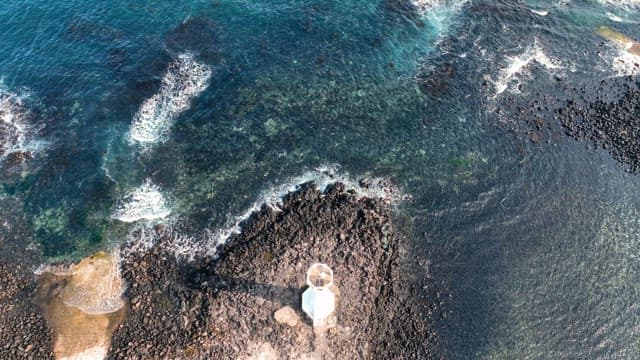 Lighthouse by the rocky seashore