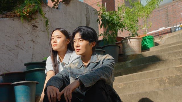 햇빛 속 야외 계단에 앉아 있는 커플