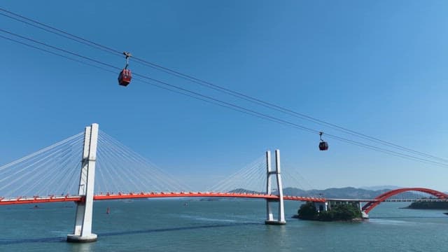 Cable cars crossing a bridge over the sea