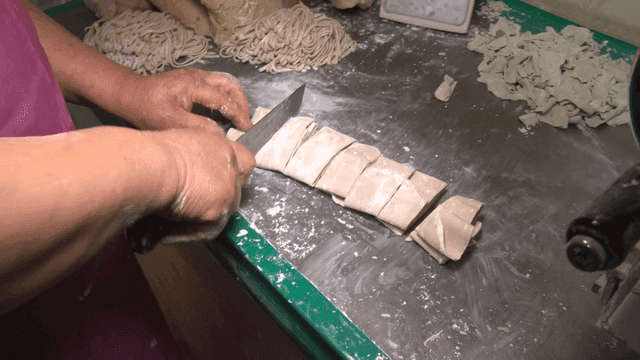 테이블 위에서 반죽을 자르는 손