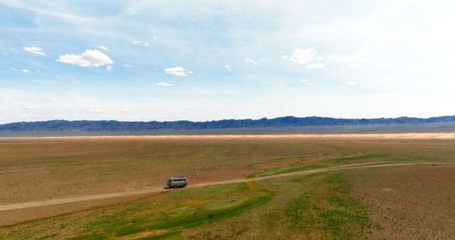 Van traveling through a vast desert