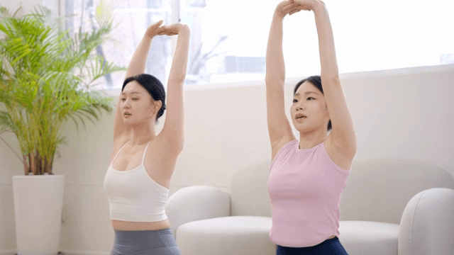 실내에서 스트레칭을 하는 두 여성