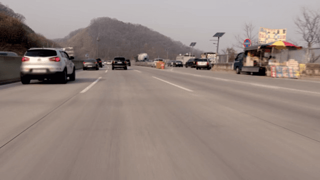 Cars running on a highway with a view of the mountains