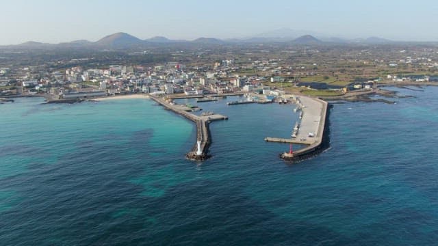 Clear turquoise sea and coastal city with lighthouse