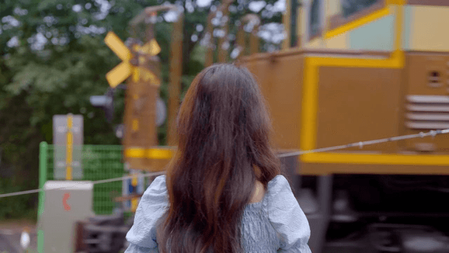 철도 건널목에서 기다리는 여성