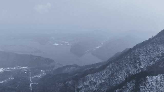Snow-covered mountains and a distant lake