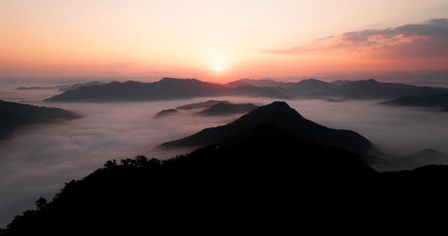 Sky Colored by Sunrise over Foggy Mountains