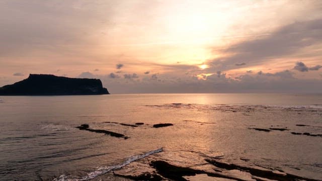 Sunset over the ocean with distant island