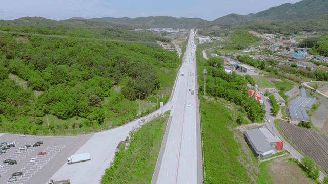 A highway stretching through lush green hills