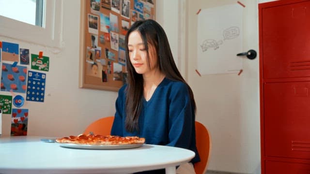 여자가 실내에서 피자 사진을 찍는 모습