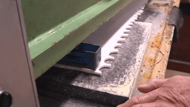 공장에서 섬유 재단 기계를 조작하는 작업자