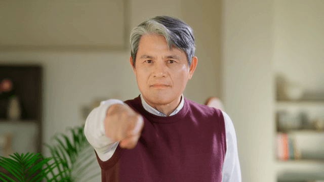 Elderly man pointing indoors
